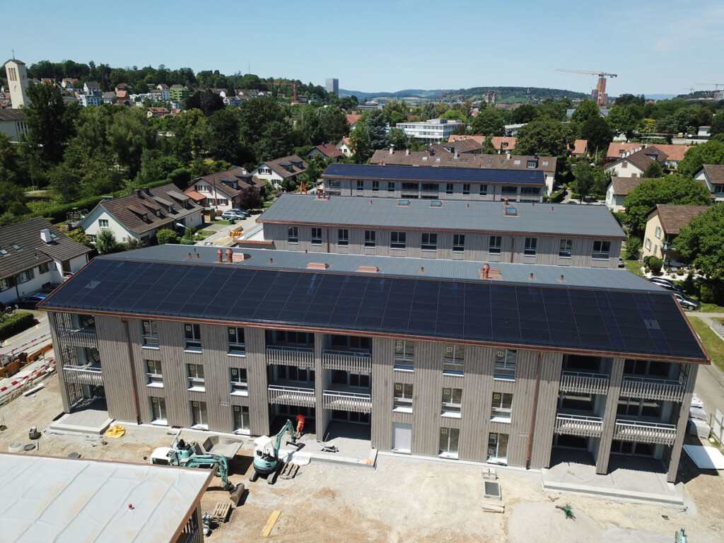Drohnenaufnahme von Solaranlagen auf dem Dach eines Bauprojekts in Winterthur